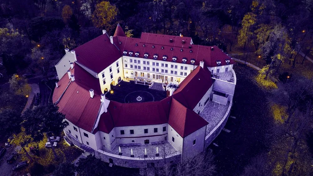 Letecký pohľad na osvetlený Šimák Zámok Pezinok za súmraku